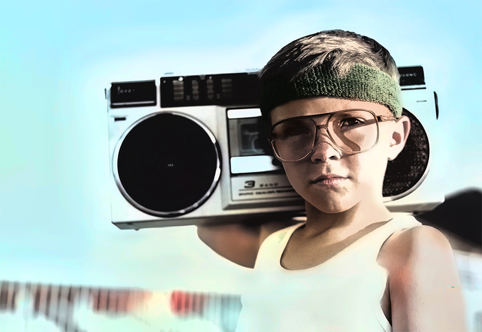 A restored color photo of a boy carrying a cassette player on his right shoulder.
